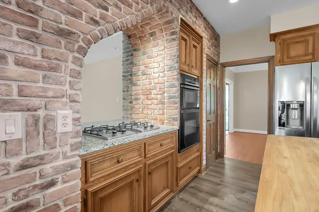 a kitchen with a stove a sink a center island and windows