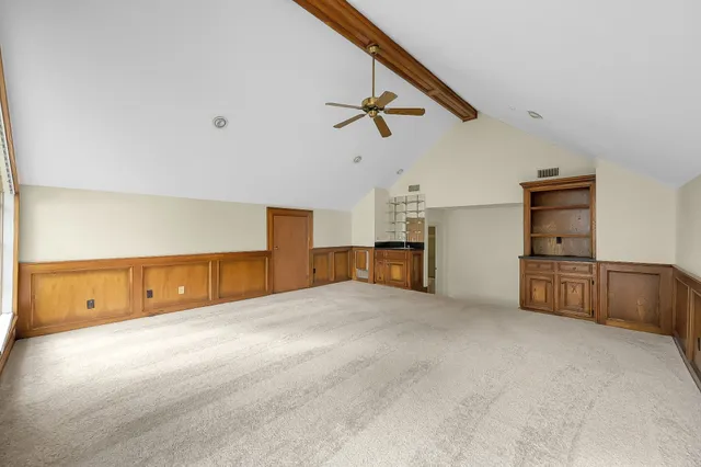 an empty room with a window and a fan