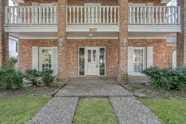 front view of a brick house with a yard