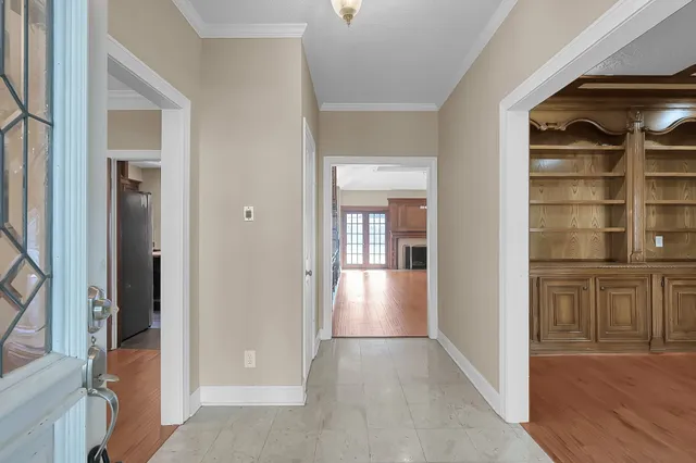 a view of a refrigerator in kitchen and an empty room