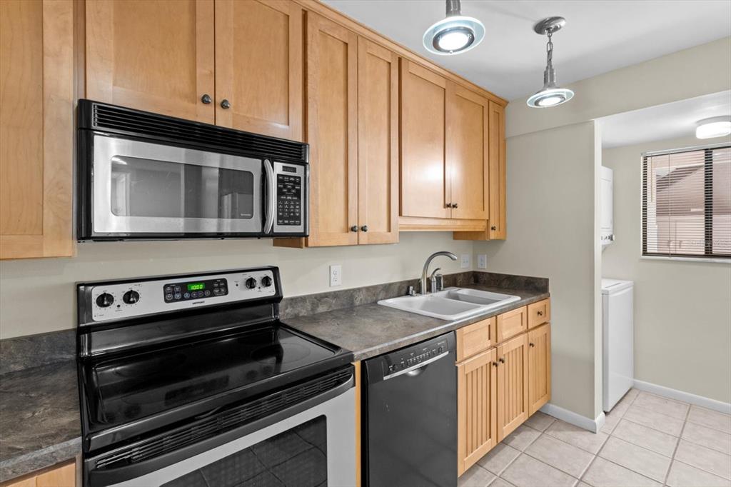 2851 Southwest 32nd Avenue, Unit B6 Ocala, FL 34474 - Photo 12 of 31 a kitchen with granite countertop a stove sink and microwave