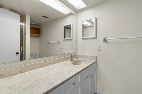 a bathroom with a granite countertop sink and a mirror