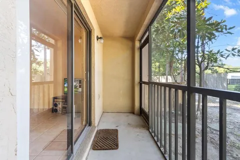 a view of a balcony with wooden floor and furniture