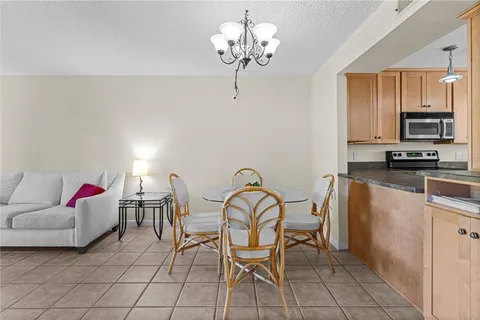 a living room with furniture a chandelier and kitchen view