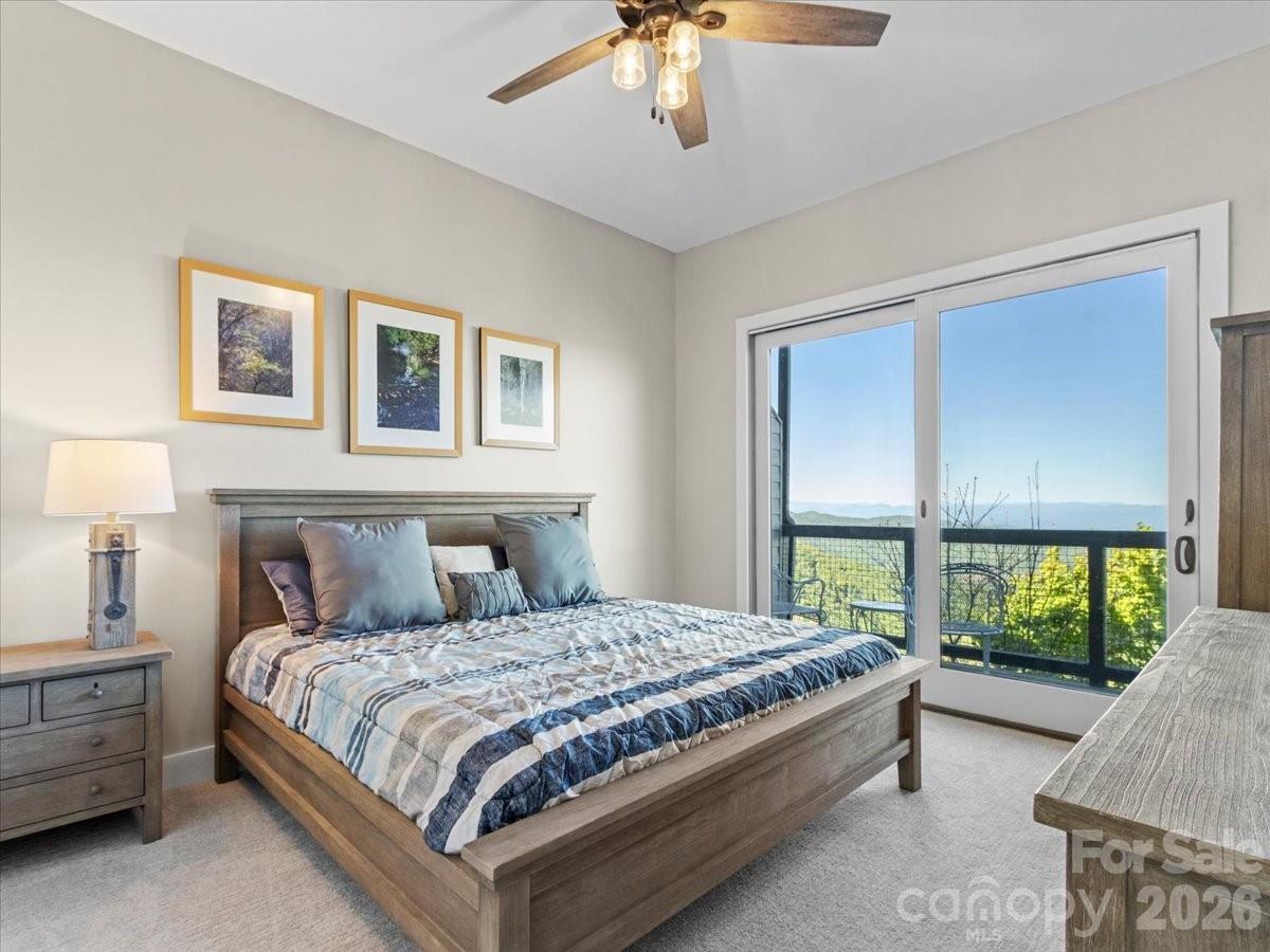 140 Slickrock Road, Unit F4 Burnsville, NC 28714 - Photo 20 of 41 a bedroom with a large bed and a chandelier