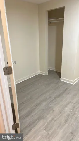 an empty room with wooden floor and entrance