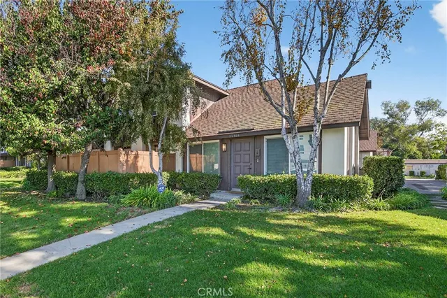 a front view of a house with a yard and trees