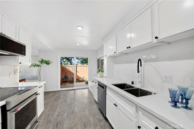 a kitchen with stainless steel appliances kitchen island sink stove and cabinets