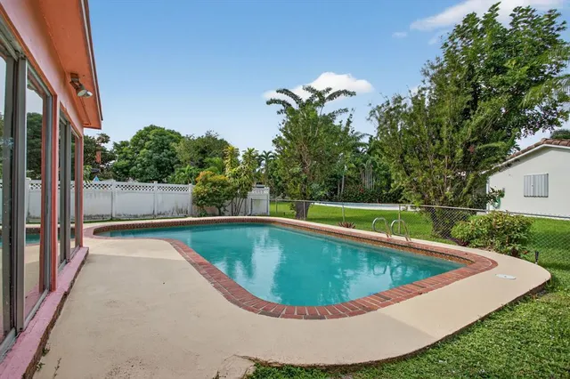 a big yard with lots of green space and house in the back
