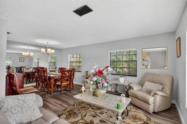 a living room with furniture dining area and a chandelier