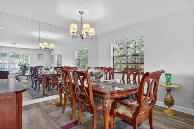 a view of a dining room with furniture a chandelier and wooden floor