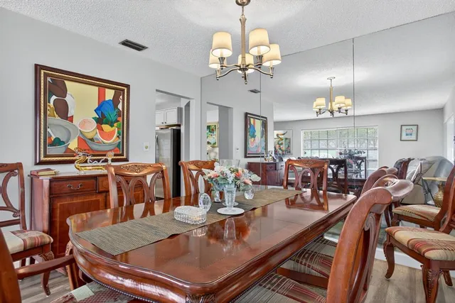 a view of a dining room with furniture wooden floor and chandelier