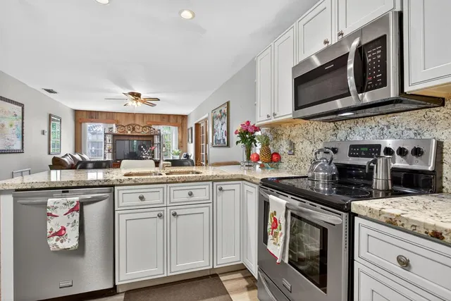 a kitchen with stainless steel appliances granite countertop a stove a microwave and a refrigerator