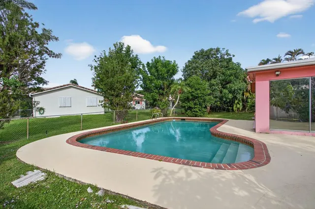 a view of a house with a swimming pool and yard