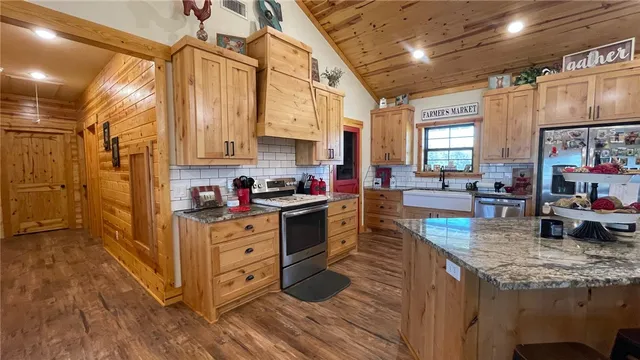 a kitchen with stainless steel appliances granite countertop a stove and cabinets