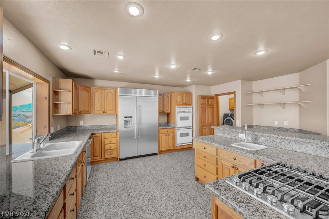 640 North Racetrack Road Henderson, NV 89015 - Photo 22 of 65 Culinary delights await in this spacious kitchen, featuring extensive counter space and natural wood cabinetry.