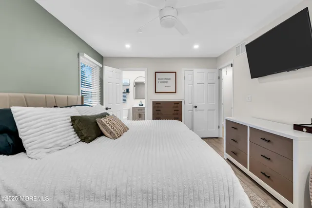 a bedroom with a large bed and a flat screen tv