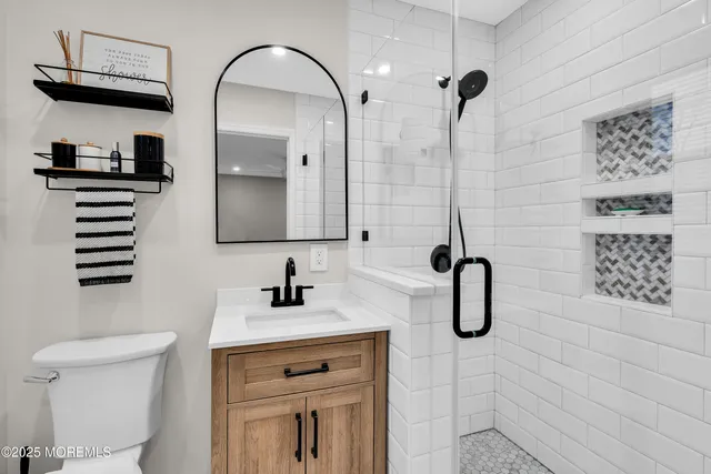 a bathroom with a sink a toilet and mirror