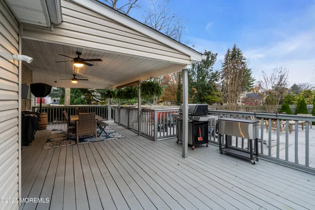 a view of a roof deck with wooden floor and fence with a floor to ceiling window