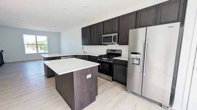 a kitchen with stainless steel appliances a refrigerator stove microwave and sink