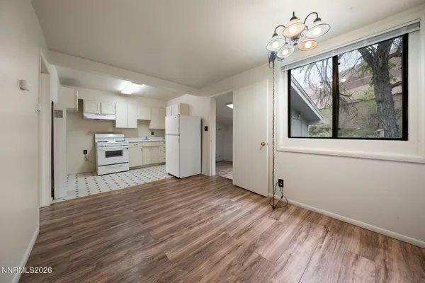 a view of a kitchen with a stove cabinets a ceiling fan and wooden floor