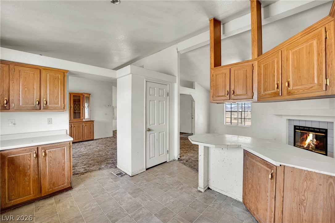 4361 Maple Road Pahrump, NV 89048 - Photo 11 of 46 A functional kitchen space featuring ample cabinetry and an inviting fireplace.