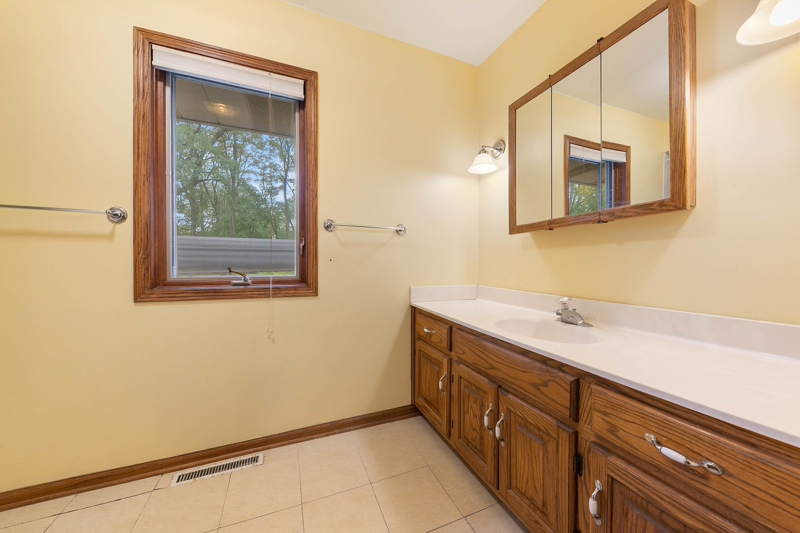 28W151 Garys Mill Road Winfield, IL 60190 - Photo 17 of 37 a bathroom with a sink a mirror and a window