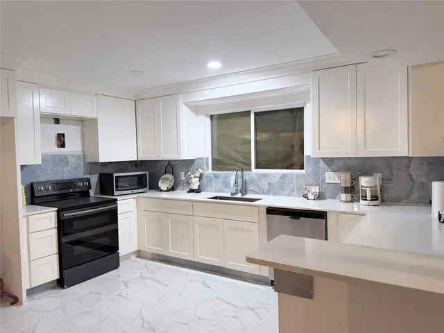 a kitchen with stainless steel appliances granite countertop a sink stove and cabinets