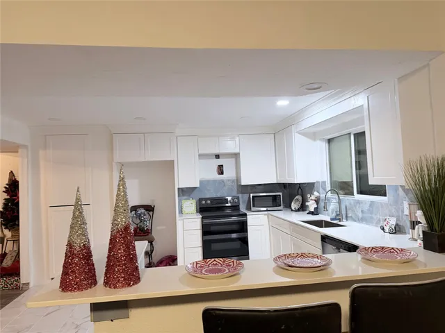 a kitchen with kitchen island white cabinets and white appliances
