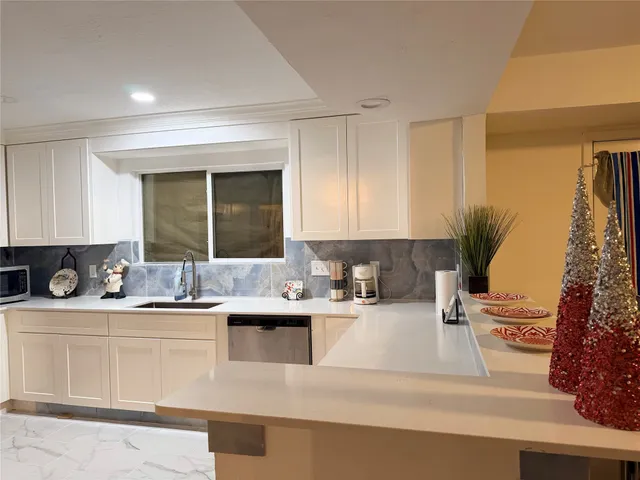 a kitchen with a sink a stove and cabinets