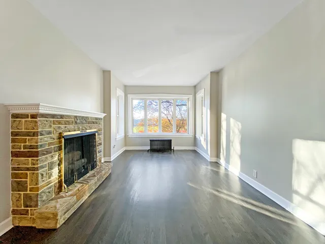 a view of a livingroom with a fireplace and window