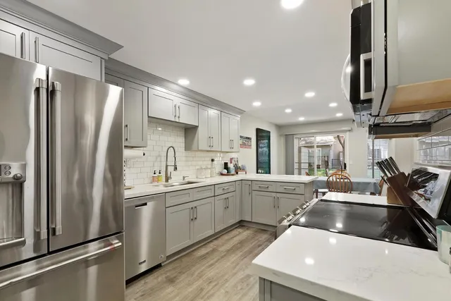 a kitchen with a sink a counter top space stainless steel appliances and cabinets