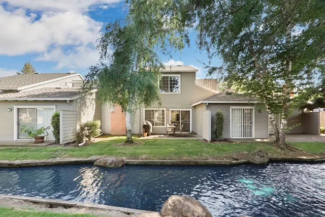 a view of backyard with a table and chairs and large tree