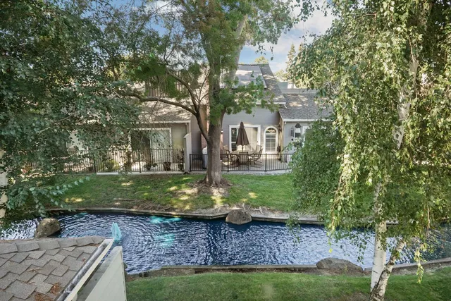 a view of a house with backyard and a tree