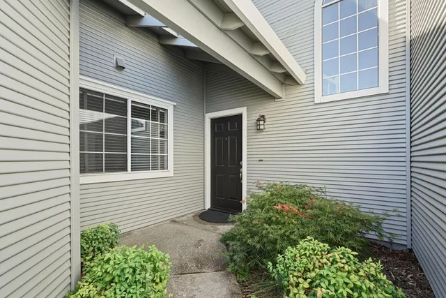 a view of a house with a yard and potted plants