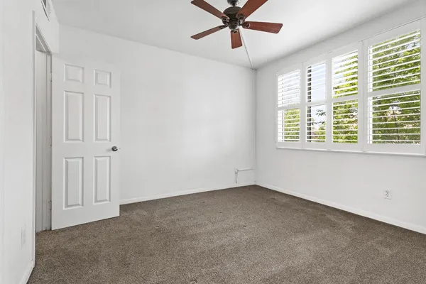 a view of a livingroom with a ceiling fan & entryway