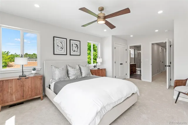 a spacious bedroom with a large bed a chandelier and a chandelier