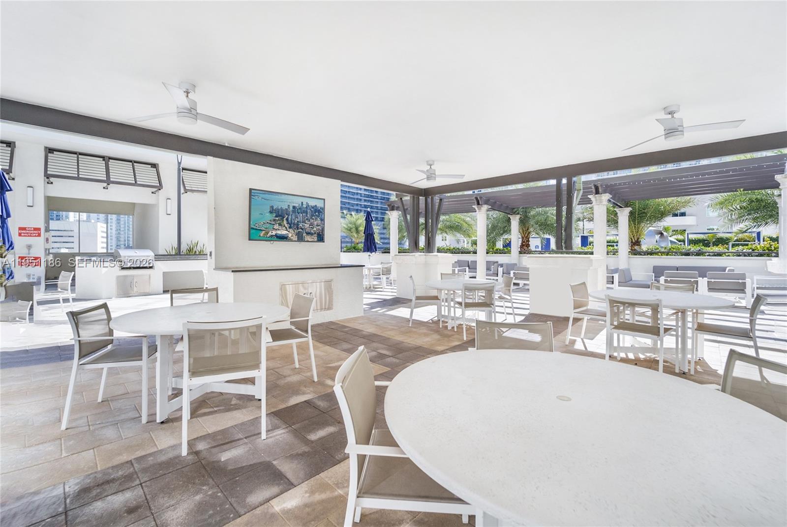999 Southwest 1st Avenue, Unit 1208 Miami, FL 33130 - Photo 15 of 17 a dining room with wooden floor and large windows