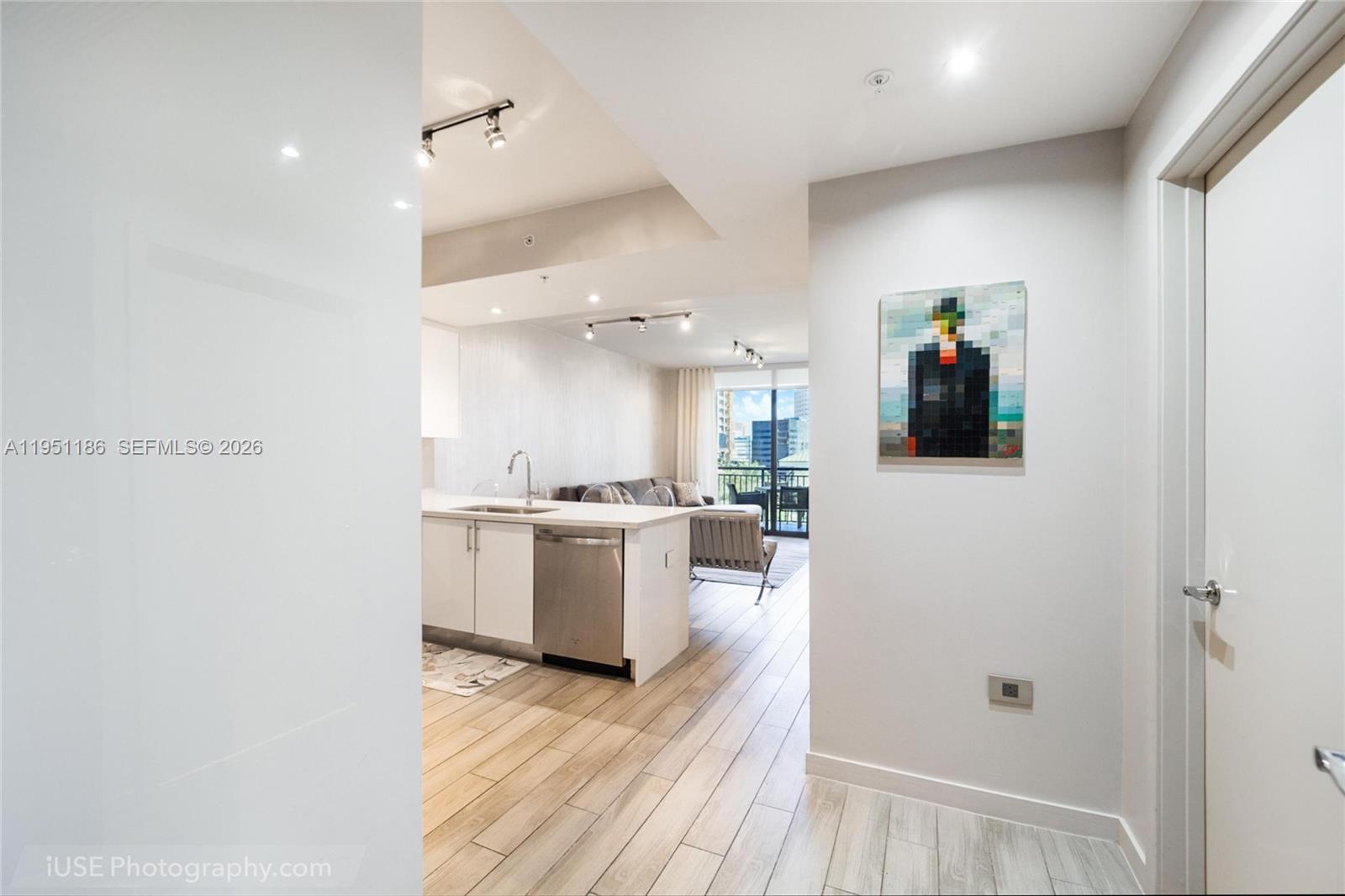 999 Southwest 1st Avenue, Unit 1208 Miami, FL 33130 - Photo 2 of 17 a view of a hallway with wooden floor and a kitchen