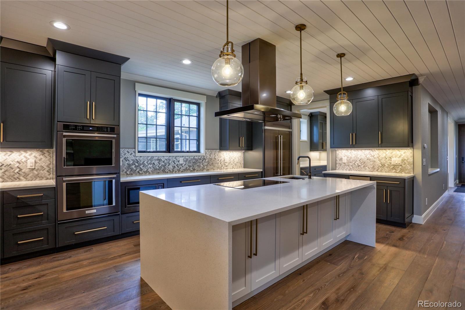 2732 South Jackson Street Denver, CO 80210 - Photo 11 of 40 a kitchen with stainless steel appliances granite countertop a sink a stove and a wooden floors