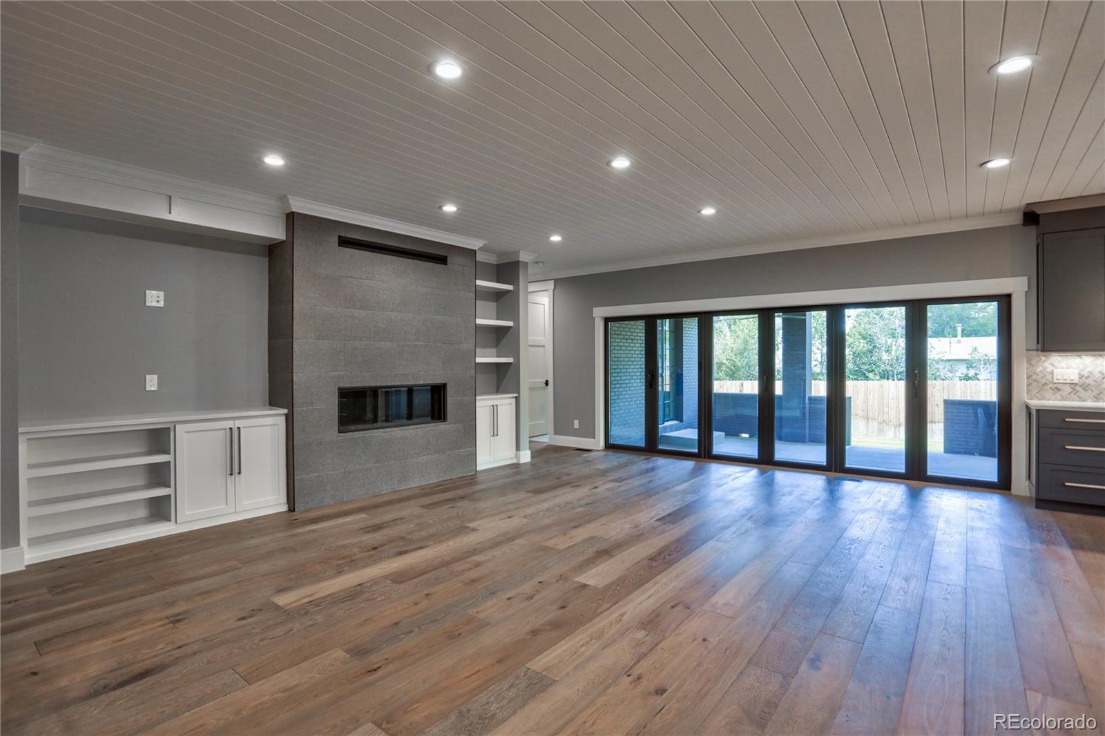 2732 South Jackson Street Denver, CO 80210 - Photo 13 of 40 an empty room with wooden floor and fireplace