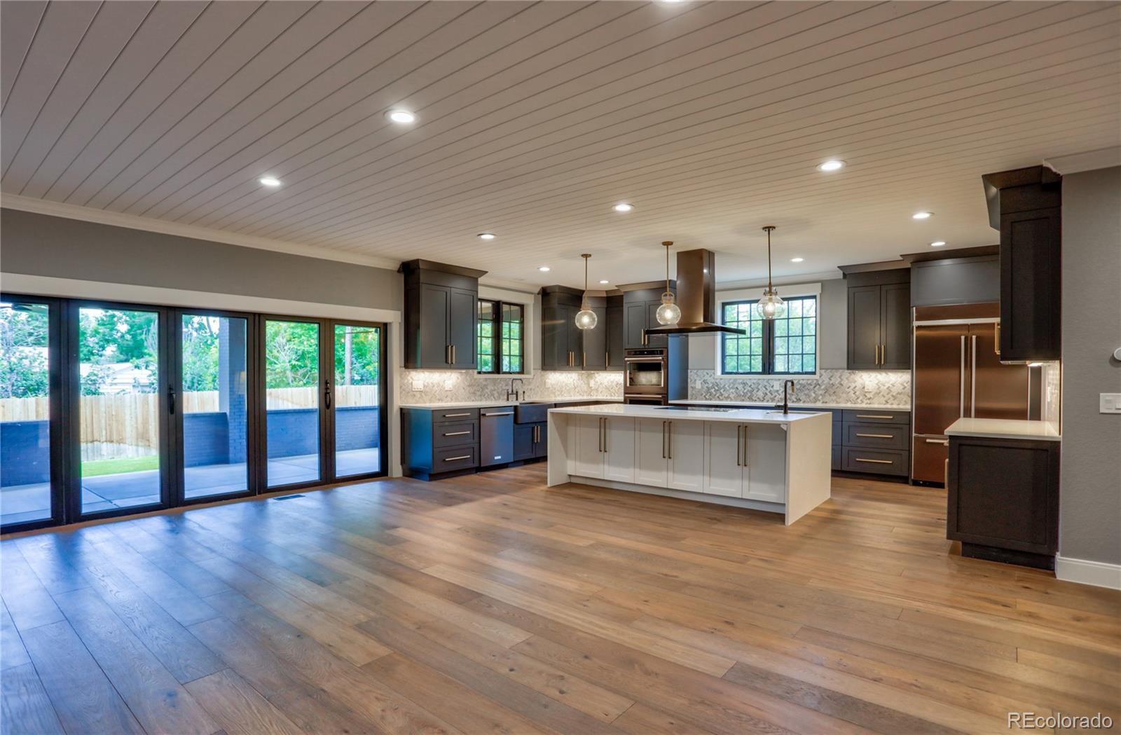 2732 South Jackson Street Denver, CO 80210 - Photo 16 of 40 a large white kitchen with large windows and stainless steel appliances
