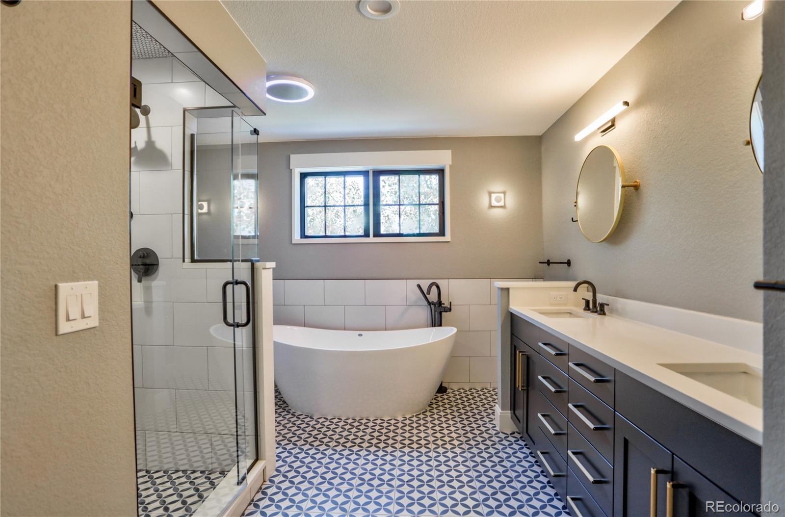 2732 South Jackson Street Denver, CO 80210 - Photo 26 of 40 a spacious bathroom with a double vanity sink a mirror and a bathtub