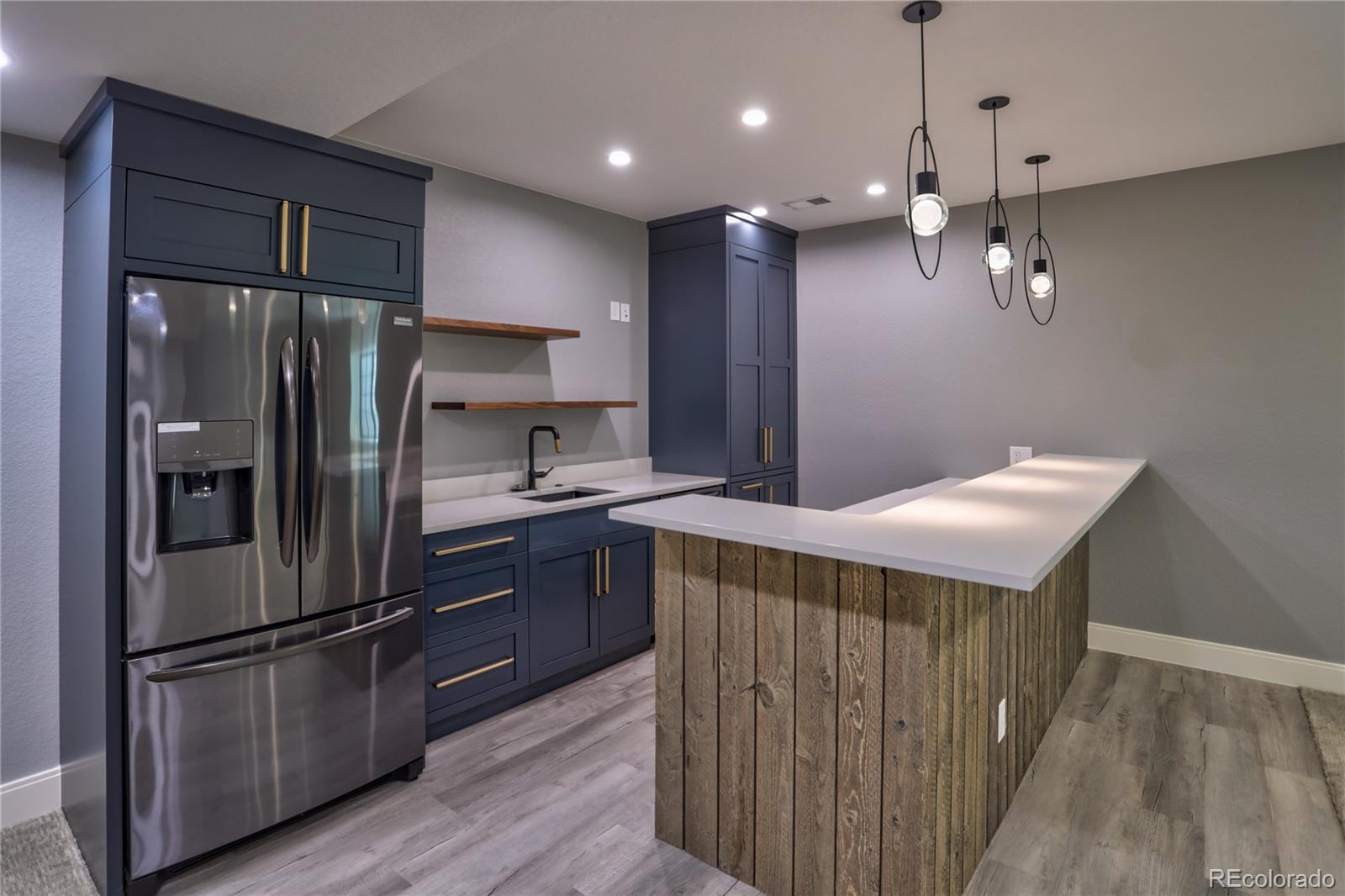 2732 South Jackson Street Denver, CO 80210 - Photo 36 of 40 a kitchen with kitchen island a counter top space wooden floor and stainless steel appliances