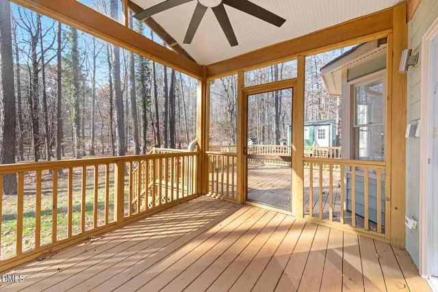 a view of a house with a wooden bench next to a yard