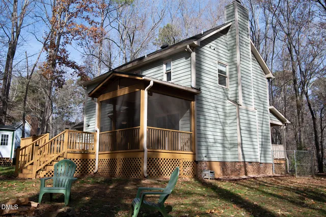 a side view of a house with a wooden fence