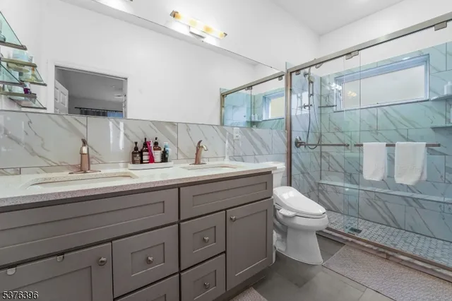 a bathroom with a toilet sink double vanity and mirror