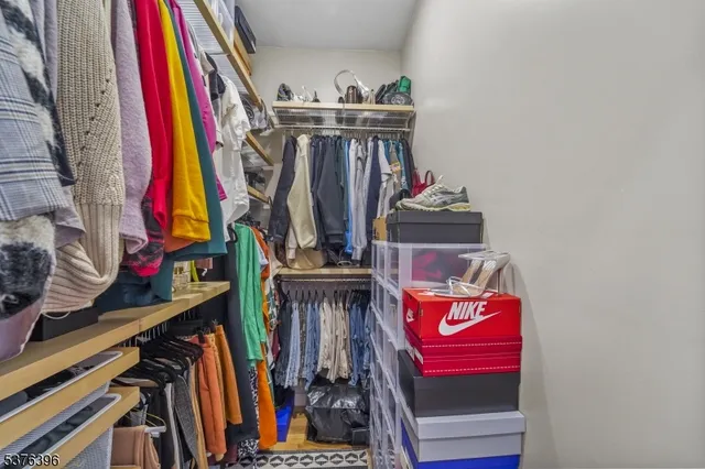a view of walk in closet with clothes
