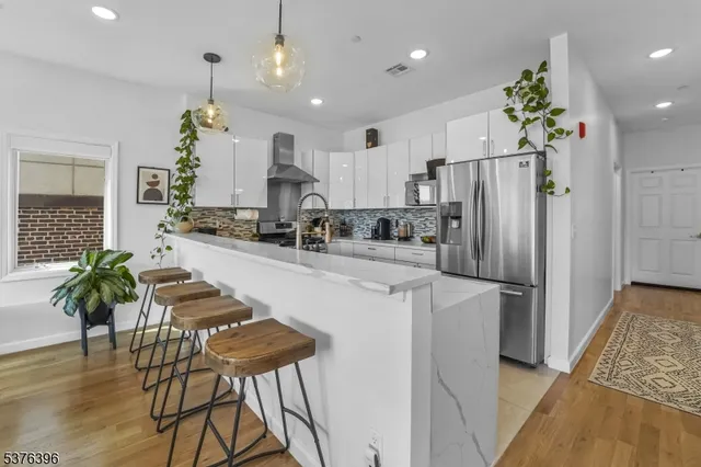 a kitchen with counter top space appliances and wooden floor