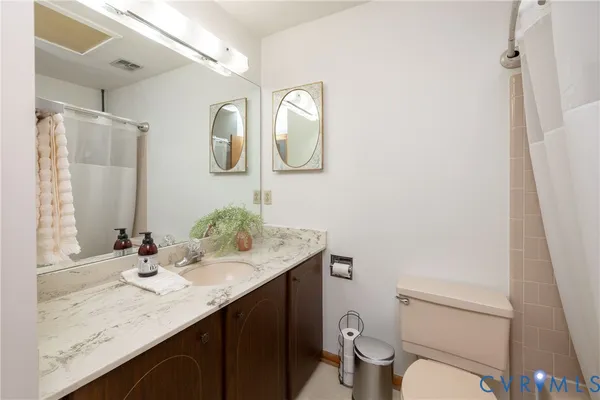 a bathroom with a granite countertop sink a toilet and a mirror